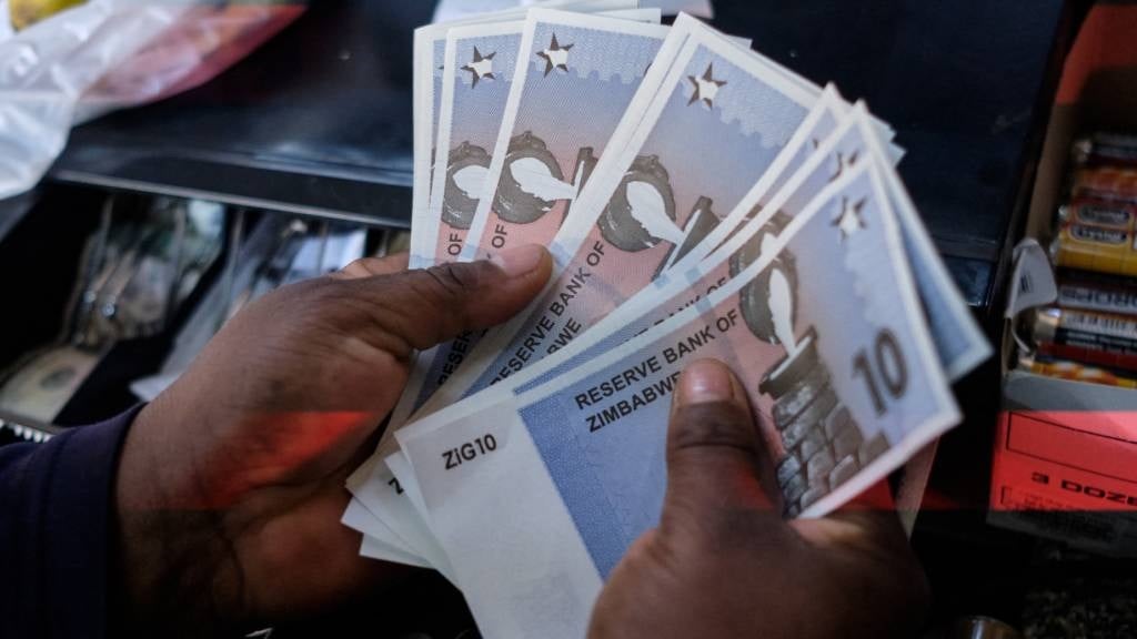 A cashier in a leading supermarket dispenses the new ZiG10 note, short for Zimbabwe Gold, from a till as change in Harare. (Jekesai Njikizana/AFP)