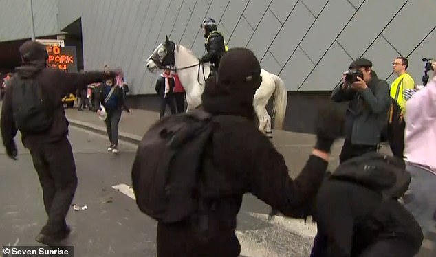 Los manifestantes contra la guerra fuera del Centro de Convenciones y Exposiciones de Melbourne fueron filmados arrojando excrementos de caballo a la policía montada.