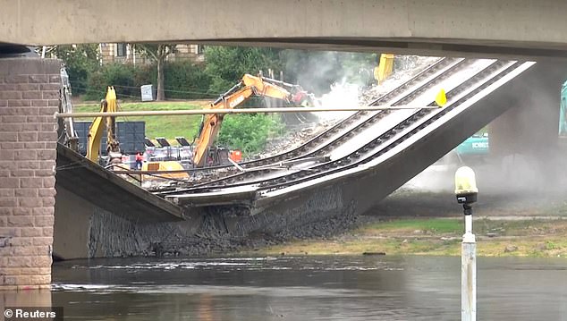 Los servicios de emergencia declaran una 'carrera contrarreloj' para evitar una gran inundación del río después de que un puente histórico se partiera por la mitad y colapsara
