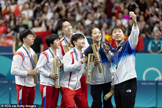 Los medallistas de plata de tenis de mesa de Corea del Norte, Ri Jong-sik y Kim Kum-yong, posan con los medallistas de bronce de Corea del Sur, Lim Jonghoon y Shin Yubin, durante la ceremonia de entrega de medallas después del partido por la medalla de oro de tenis de mesa - dobles mixtos en el cuarto día de los Juegos Olímpicos de París 2024