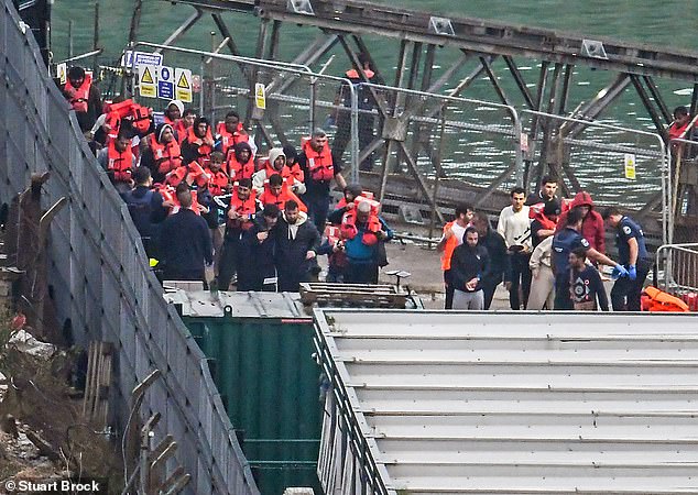 Los funcionarios de la Fuerza Fronteriza Británica escoltan a los inmigrantes hasta los muelles de Dover en Kent, el 21 de septiembre