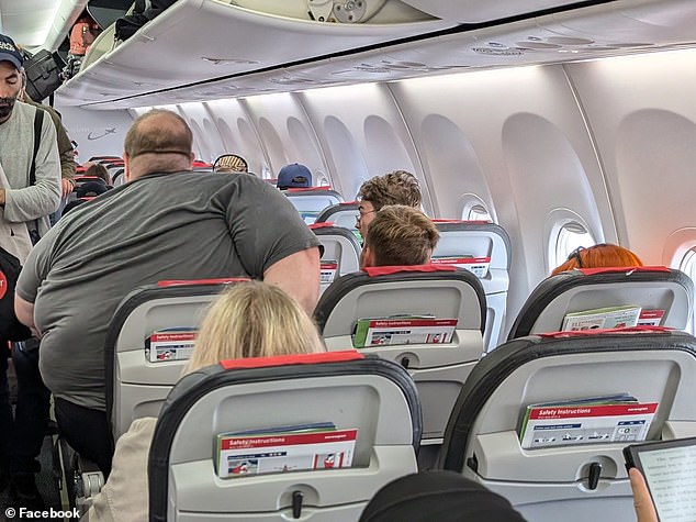 El pasajero de talla grande fue fotografiado por un compañero de viaje mientras luchaba por ponerse cómodo en su asiento del pasillo durante un vuelo de Helsinki a Copenhague el lunes.