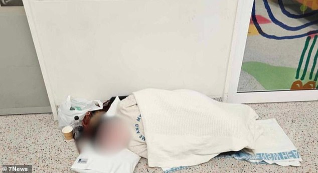 Una mujer es fotografiada en una cama improvisada en el Departamento de Emergencias del Hospital Blacktown debido a que la sala de espera estaba abarrotada de pacientes.