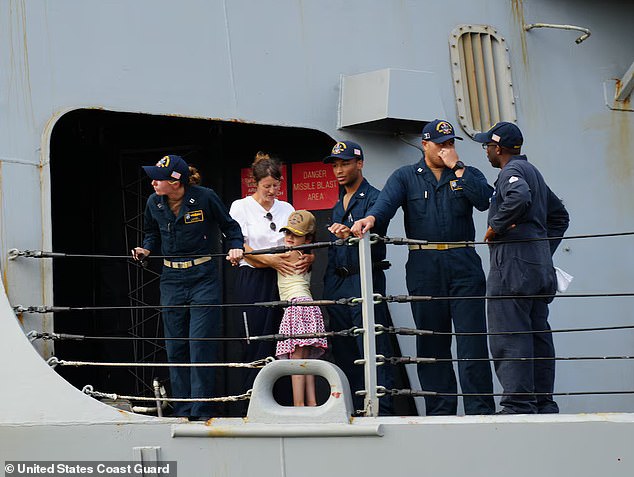 Una mujer y su hija, que quedaron varadas a casi 1.600 kilómetros de la costa de Hawái cuando el huracán Gilma tocó tierra, se abrazan en la cubierta del USS William P. Lawrence mientras el barco se acerca a la Base Conjunta Pearl Harbor-Hickam en Honolulu el 28 de agosto de 2024.