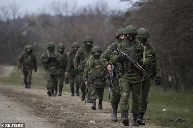 Hombres armados, que se cree que eran militares rusos, cerca de la ciudad de Simferopol en Crimea en marzo de 2014. La invasión inicial incluyó el subterfugio de que las tropas se despojaran de sus insignias.