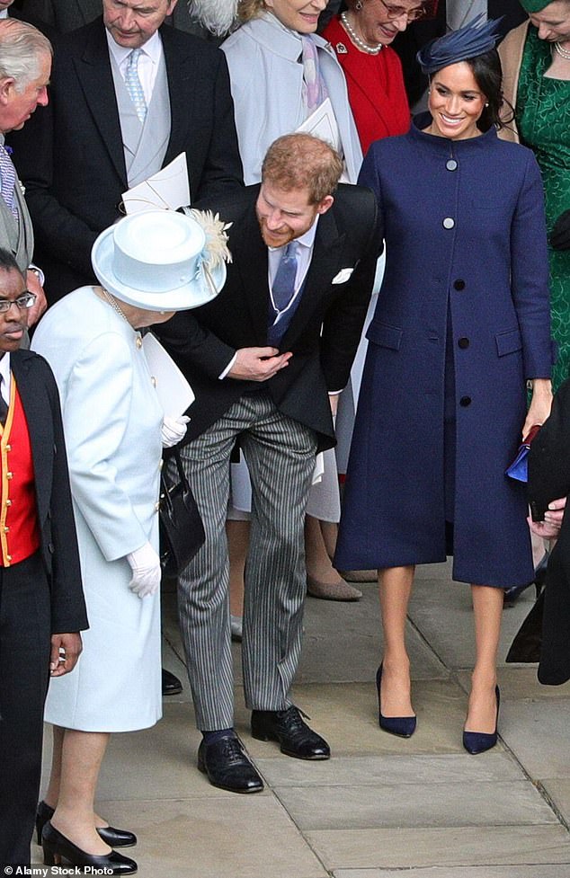 El príncipe Harry, con su esposa Meghan, hablando con la difunta reina Isabel fuera de la Capilla de San Jorge después de la boda de la princesa Eugenia y Jack Brooksbank en 2018.