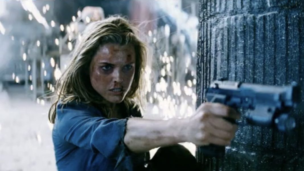 Keri Russell shooting gun while sparks fly behind her in Mission: Impossible III