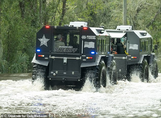 Los equipos de rescate de la policía con monstruosos vehículos anfibios van esta tarde casa por casa en una zona gravemente inundada cerca de Tampa.