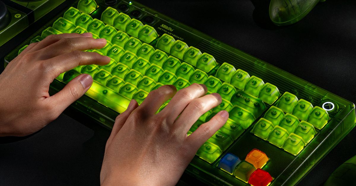 A pair of hands typing on the 8BitDo Retro 87 Mechanical Keyboard - Xbox Edition while it’s glowing green.