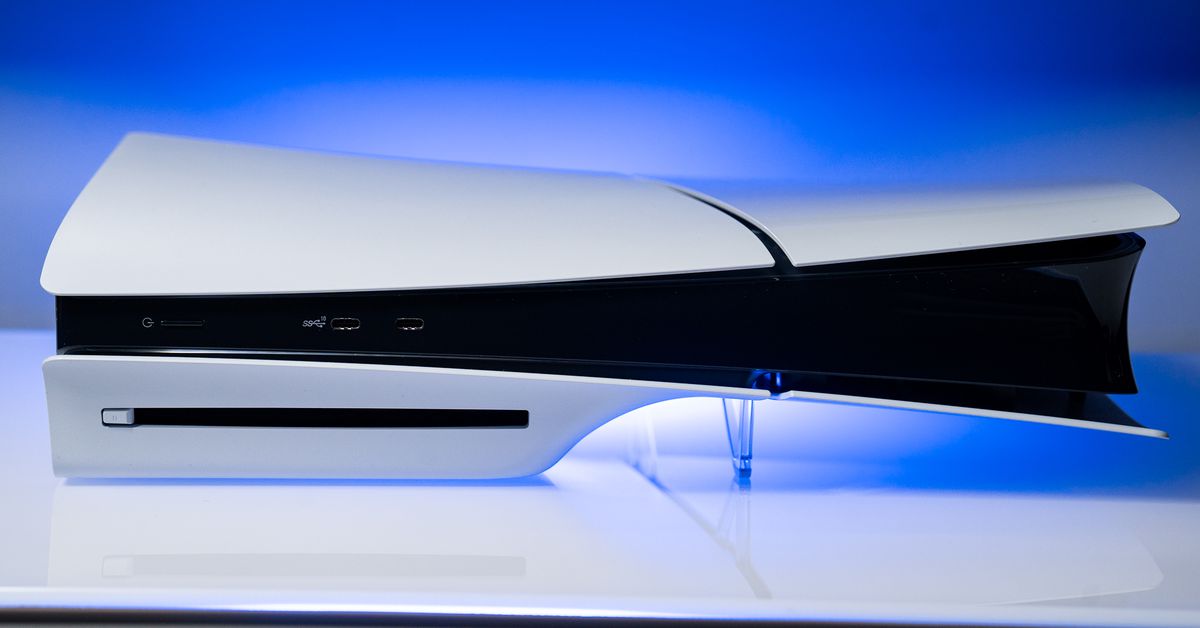 The slim PlayStation 5 with a disc drive, sitting on a white entertainment center.