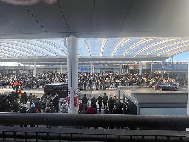 Los pasajeros se encuentran fuera de la terminal sur del aeropuerto de Gatwick después de que fuera evacuada el viernes por la mañana tras un 