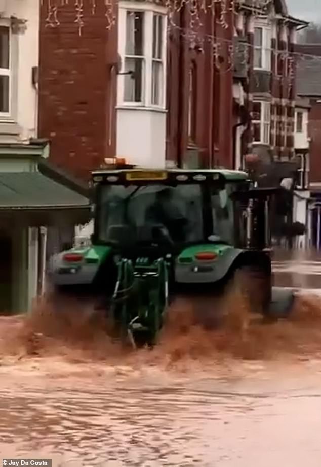 Este es el momento en el que se ve a un conductor de tractor circulando por una calle inundada en Tenbury Wells.