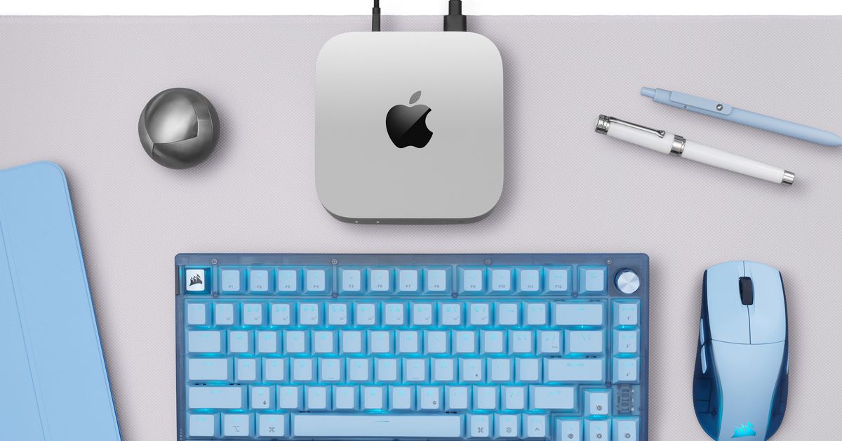 The Corsair K65 Plus wireless keyboard and the M75 wireless mouse in glacier blue on a desk.