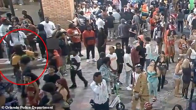 Imágenes impactantes publicadas por la policía muestran al sospechoso con una camisa amarilla caminando tranquilamente entre la multitud de juerguistas de Halloween antes de darse la vuelta y disparar su arma.