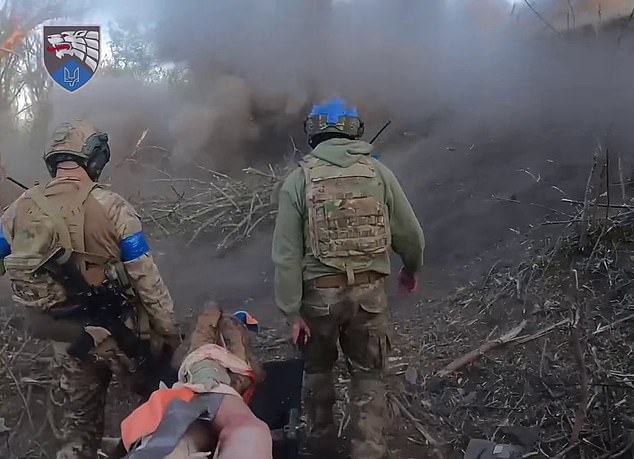 Una nueva e increíble imagen desde el frente muestra a valientes soldados ucranianos llevando a un camarada herido en una camilla a través de los disparos rusos sin inmutarse.