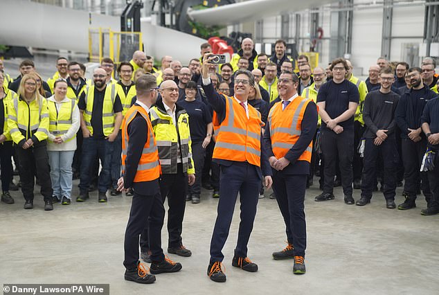 Chris Stark, director de Clean Power 2030, el director de planta Andy Sykes y el secretario de Net Zero, Ed Miliband, tomando una fotografía durante una visita a la fábrica de turbinas de Siemens Energy en Hull.