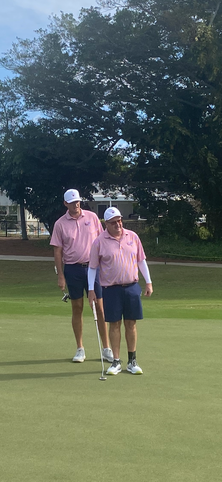 Carl Mistretta, executive director of First Tee Gold Coast, looks over putt with son Tyler during Monday's competition.