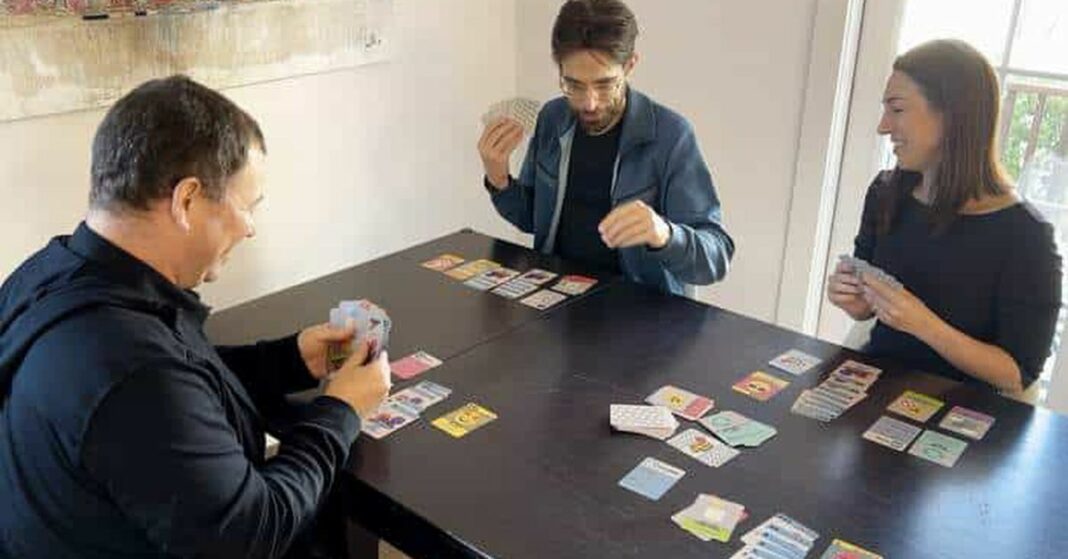 A group of people playing a card game, One Billion Users.