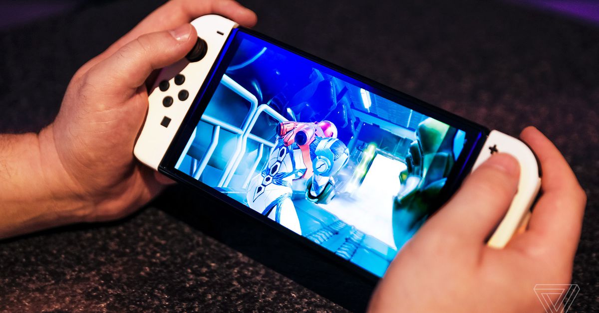 A pair of hands holding the Nintendo Switch OLED