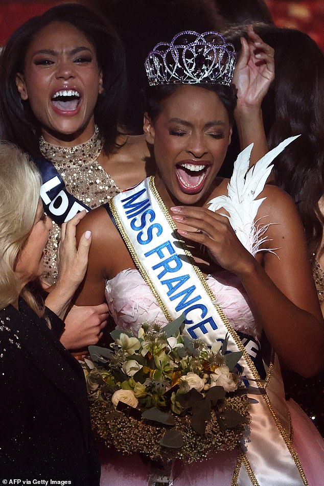 La campeona del concurso sonrió con un vestido rosa y blanco cuando le otorgaron el título.