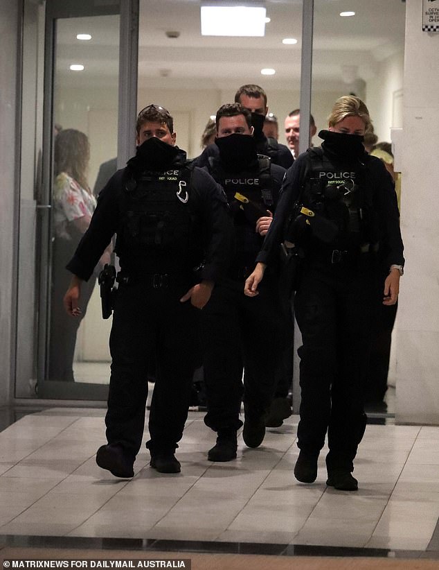 Imágenes dramáticas tomadas poco después de las 8 de la tarde mostraron a unas dos docenas de detectives y policías antidisturbios vestidos con pasamontañas descendiendo a un edificio de apartamentos en Baker Street, a menos de 100 metros de las oficinas de Asistencia Legal, que aún estaban siendo examinadas forensemente.