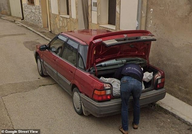 La foto muestra a un hombre cargando lo que parece ser una bolsa para cadáveres en el maletero de un coche rojo, informan los medios locales.