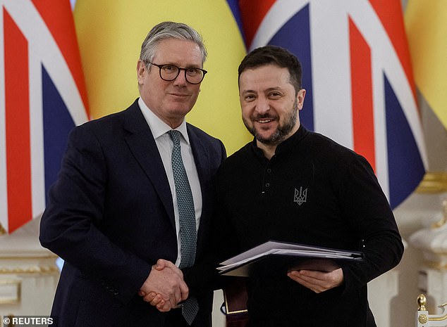 El primer ministro británico, Keir Starmer, y el presidente de Ucrania, Volodymyr Zelenskiy, se dan la mano tras la ceremonia de firma.