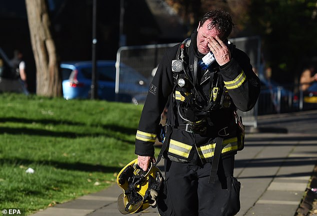 Más de 150 bomberos han quedado con problemas de salud crónicos después de abordar el mortal incendio de la Torre Grenfell. En la imagen: un bombero reacciona después de combatir el incendio.