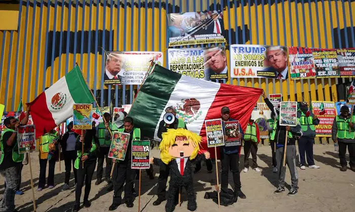 Deportados rompen piñata de Donald Trump frente al muro fronterizo de Tijuana
