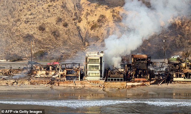 Una casa parece estar sola, intacta, en medio de un mar de ruinas humeantes en el incendio de Palisades en Malibú, California.