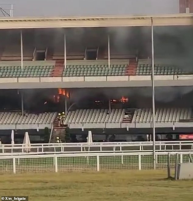 Según los informes, CCTV capturó a un hombre prendiendo fuego a la tribuna del hipódromo de Caulfield, declarada patrimonio histórico (en la foto, bomberos en el lugar)