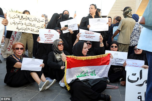 Mujeres iraquíes sostienen pancartas y corean consignas durante una protesta contra la enmienda de la Ley del Estatuto Personal, en la plaza Tahrir, en el centro de Bagdad, Irak.