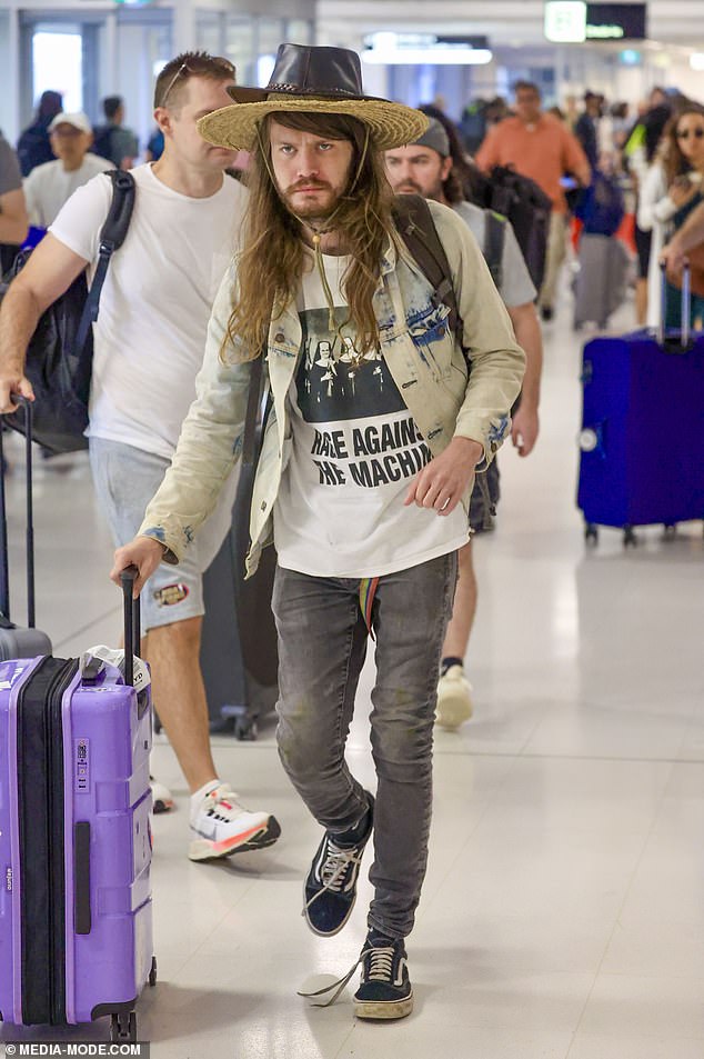 Chance Hogan, de 27 años, (en la foto) fue visto sacudiendo una extraña mirada inspirada en Crocodile Dundee el viernes mientras deambulaba por el aeropuerto de Sydney luego de una muy breve visita a Australia