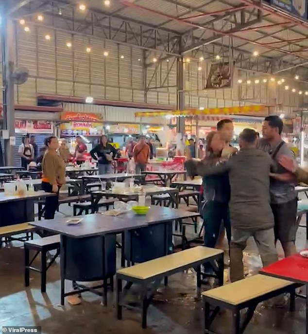 Momento en que el triángulo amoroso estalla en una pelea masiva cuando el marido y el amante de una mujer tailandesa descubren que ella los ha estado engañando con un británico de pelo gris, que derriba a su rival con un movimiento de judo.
