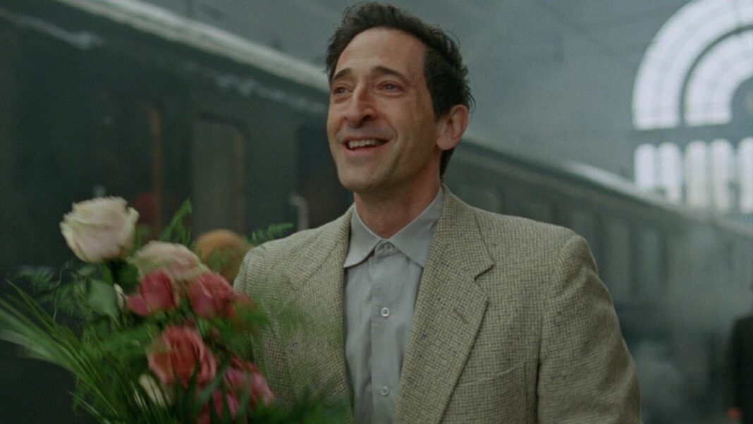 Adrien Brody in The Brutalist holding flowers.