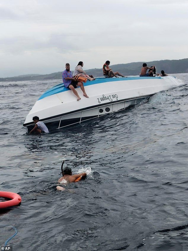 Una mujer australiana murió después de un bote de snorkel con 13 turistas volcados en la isla indonesia de Bali (el bote se ve al revés en aguas frente a Denpasar)