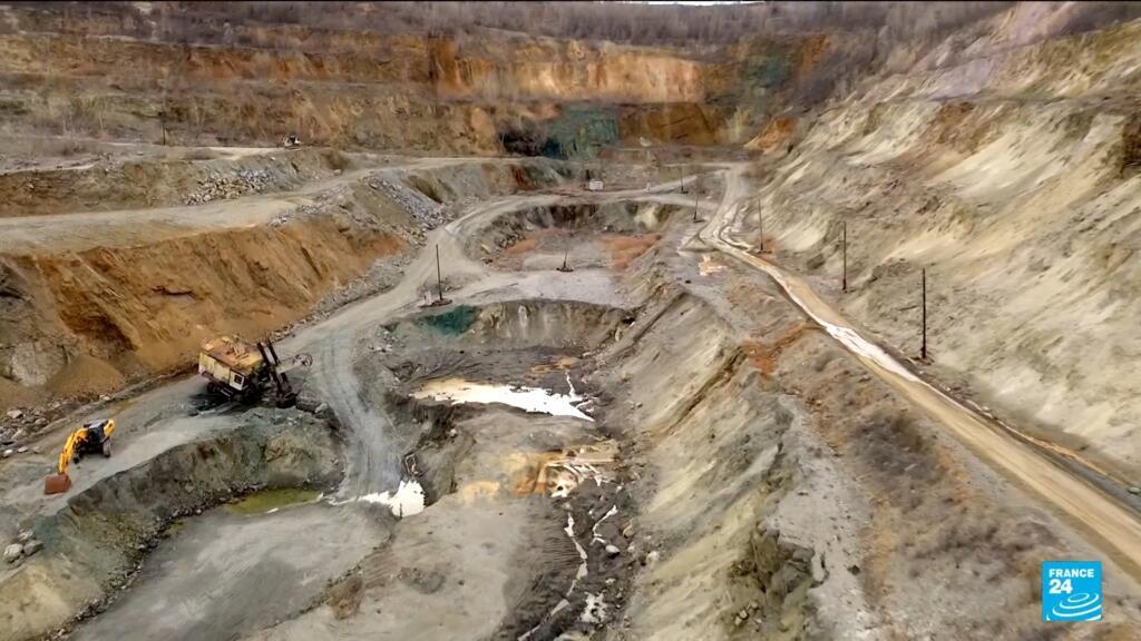 Un mineral '50 -50 'trata con los trajes de EE. UU. En un pueblo minero de grafito
