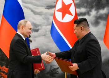 Vladimir Putin y Kim Jong Un dándose la mano en una ceremonia de firma.
