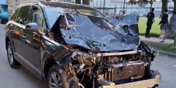 Un SUV negro severamente dañado después de golpear a una multitud.