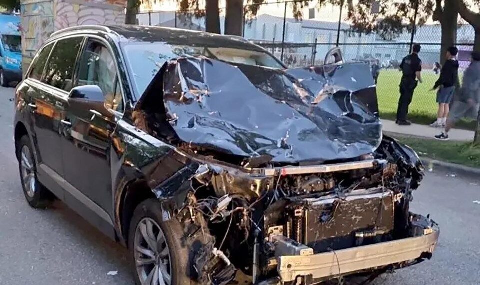 Un SUV negro severamente dañado después de golpear a una multitud.