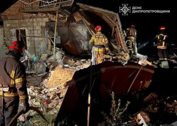 Los bomberos que luchan contra un fuego en una fábrica dañada.
