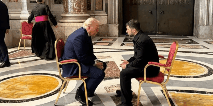 Donald Trump y otro hombre sentados en sillas frente a otros.