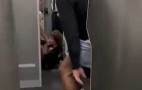 Hombre en pantalones cortos y descalzos ayudando a un pasajero en un avión.