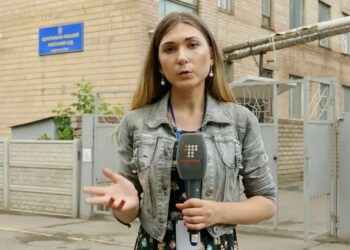 Un periodista ucraniano que informa fuera de un edificio.