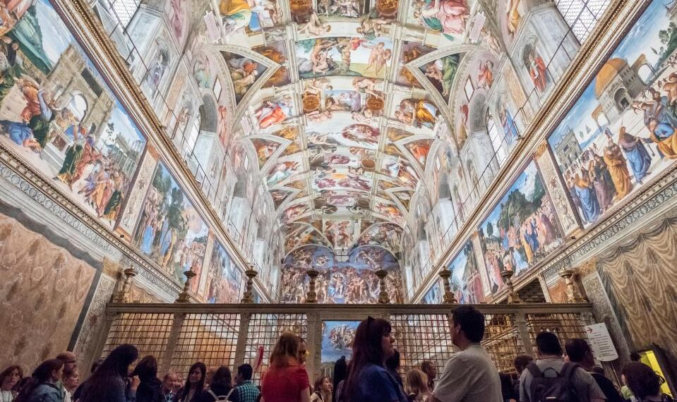 Turistas que ven el techo de la Capilla Sixtine de Michelangelo.