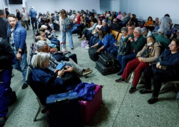 Pasajeros que esperan en una estación de tren después de un corte de energía.