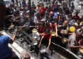 Los palestinos desplazados se reúnen para recolectar porciones de alimentos cocinados en una distribución de caridad en Jabalia en la franja del norte de Gaza el 19 de mayo de 2025.