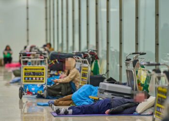 Gente que duerme en el piso de una terminal del aeropuerto.