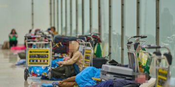 Gente que duerme en el piso de una terminal del aeropuerto.