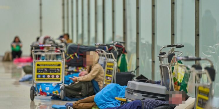 Gente que duerme en el piso de una terminal del aeropuerto.